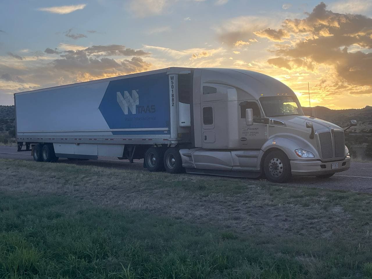 RUNFOREST tractor-trailer parked roadside at sunset